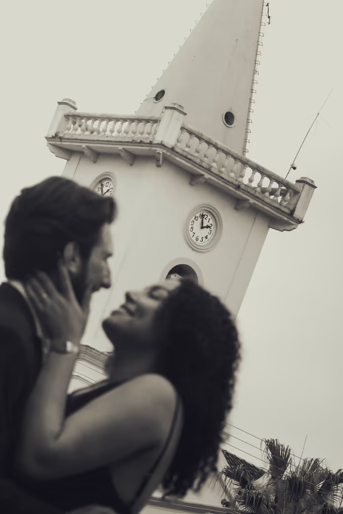Casal em frente a torre do relógio em preto e branco